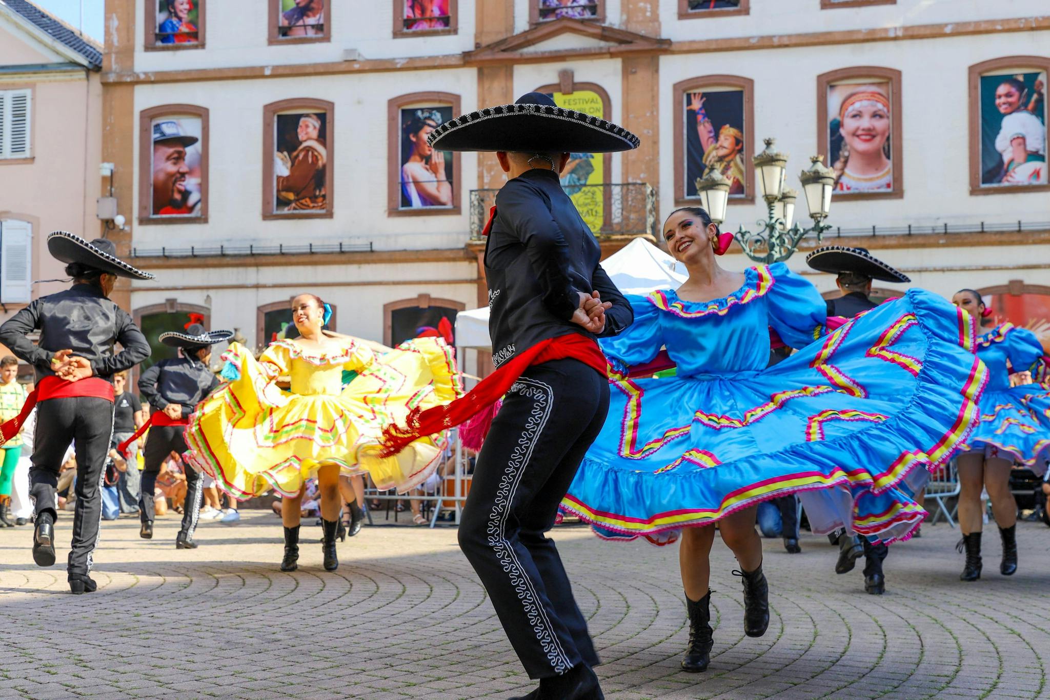 Colorful traditional Mexican dancers performing in a lively town square.
